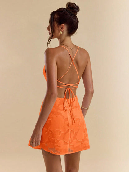 Chic solid pink bodycon mini dress with low back, tie straps, and textured A-line silhouette.