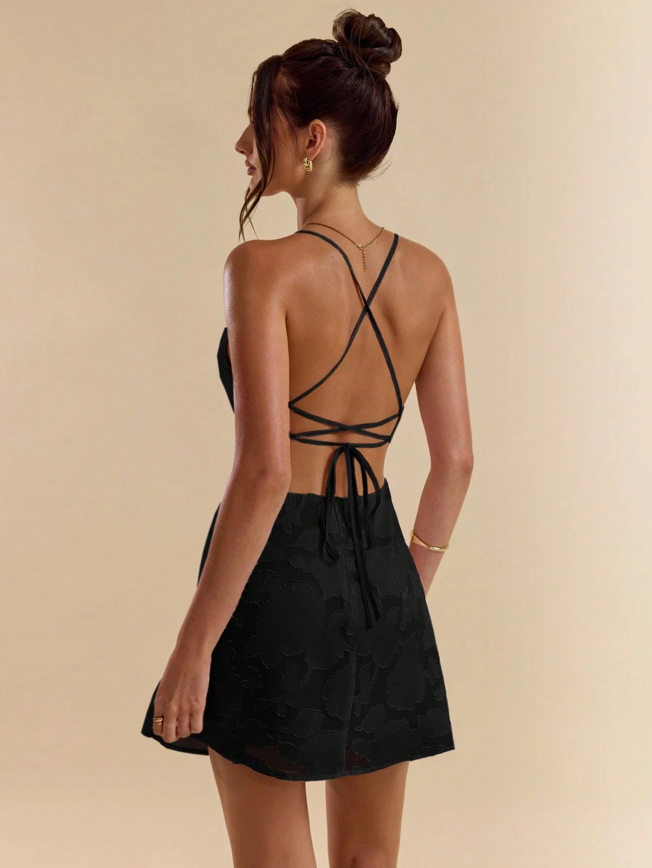 Chic solid pink bodycon mini dress with low back, tie straps, and textured A-line silhouette.